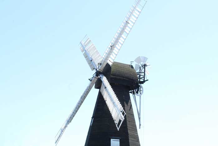 slide07 The sweeps of Herne Windmill set against a clear blue sky.